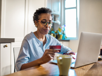 a person sitting at a table with a laptop and a cup of coffee